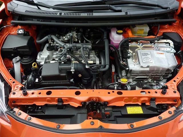 A car engine bay with various components, cables, and hoses.