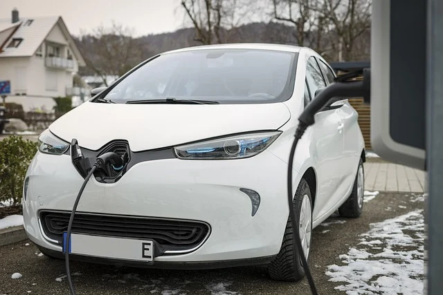 Battery c rating: A white electric car charging at a station in a snowy outdoor setting.
