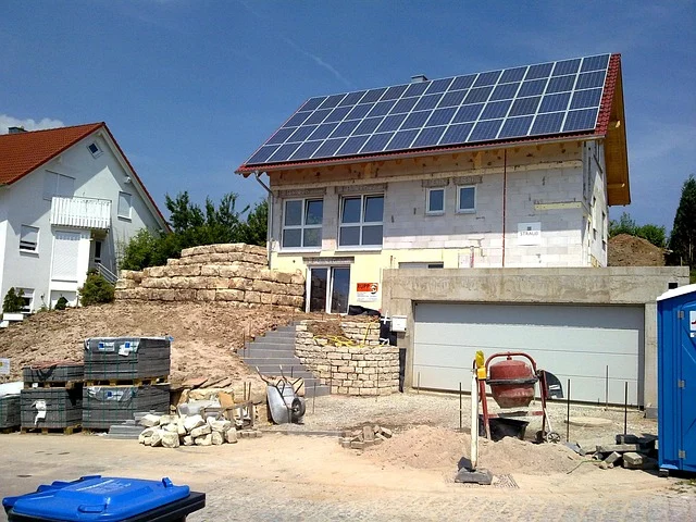House under construction with many solar panels on the roof.
