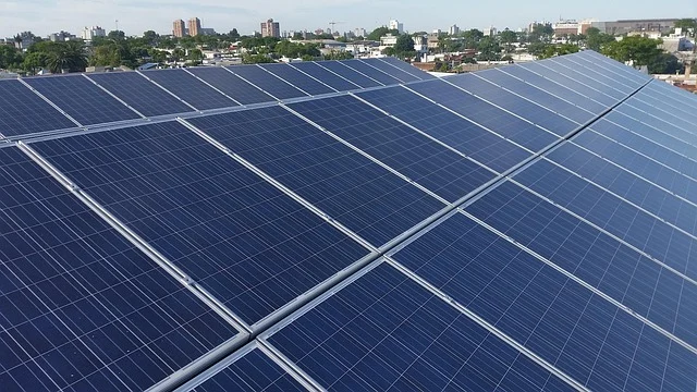Are solar panels worth it in canada: Solar panels on a rooftop with a city skyline in the background.