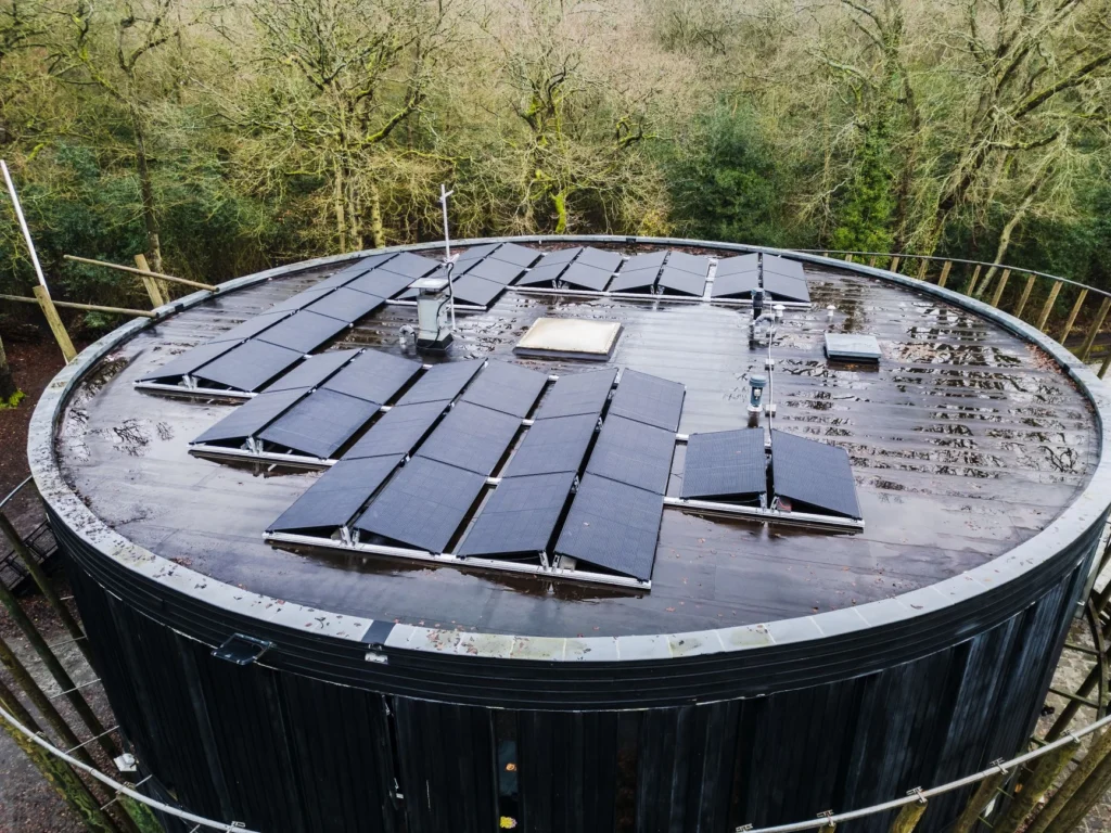Solar panels australia cost: Solar panels on a round roof surrounded by trees.