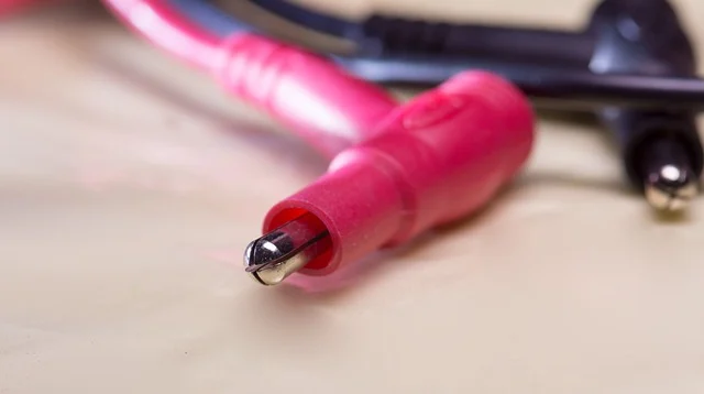 Close-up of red and black electrical wires or multimeter probes.