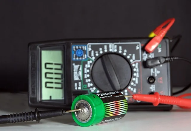 A multimeter measuring voltage of a battery, showing 0.00 on display.