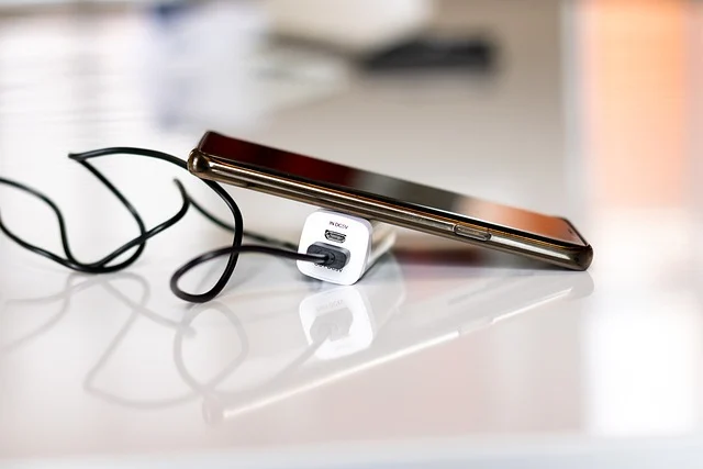 Smartphone charging with a white power adapter and black cable