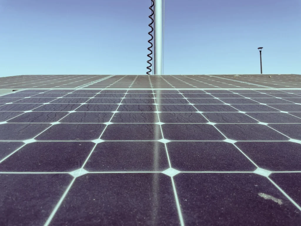 Dirty solar panels with visible cracks and dust under a clear sky.