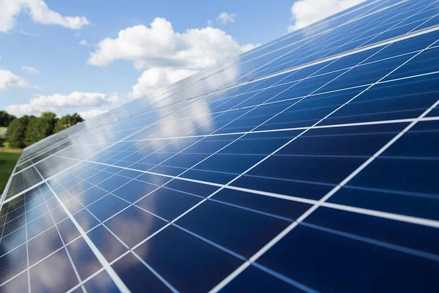 Close-up of solar panels under a blue sky with clouds