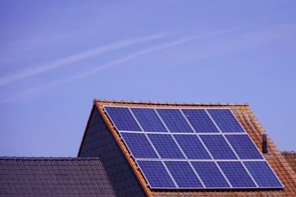 Solar panels installed on a residential roof under a clear blue sky.