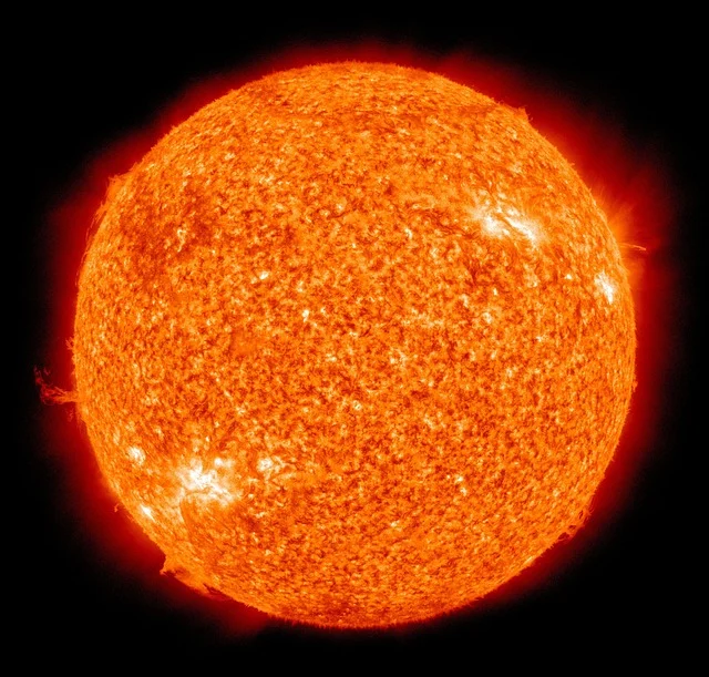 The sun, a fiery orange sphere against a black background