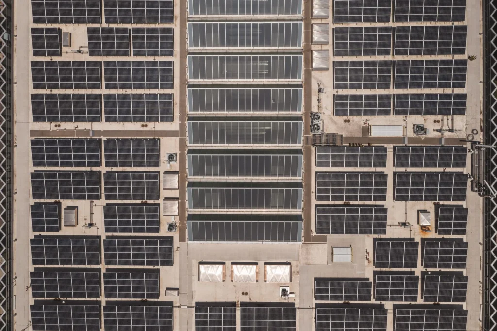 An aerial view of solar panels installed on a large rooftop.