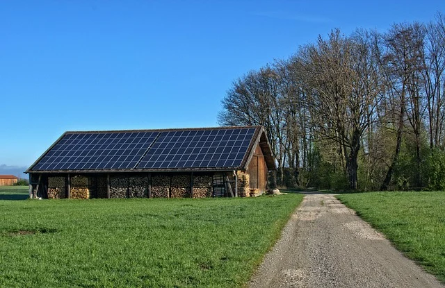 Solar panels on a barn roof with firewood storage.