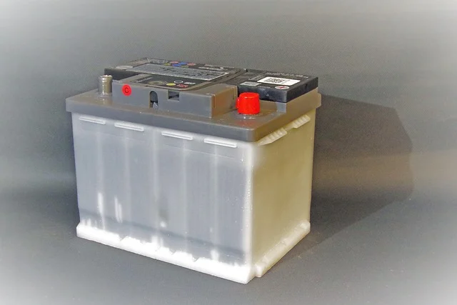 Battery voltage chart: A lead-acid car battery with visible terminals.
